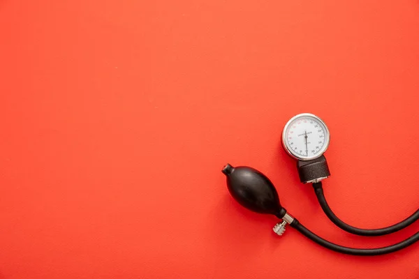 Έλεγχος Υπέρτασης Μέτρηση Αρτηριακής Πίεσης Ιατρικό Σφυγμομανόμετρο Φόντο Κόκκινου Χρώματος — Φωτογραφία Αρχείου