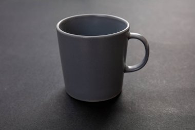 Siyah arka planda kahve fincanı. Sıcak içecek kupası maketi. Sapı reklamlı gri renkli boş bardak, damgalama şablonu