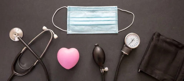 血圧計 医療用聴診器 黒い背景色の保護面マスク コロナウイルスの保護と治療の概念 — ストック写真
