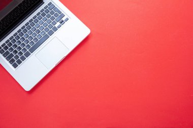 Kırmızı arkaplanda dizüstü bilgisayar. Dizüstü metal gümüş rengi üst görünümü aç. Ev ofisi kavramı, kopyalama alanı, şablon