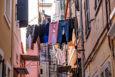 Yunanistan 'ın eski Corfu kasabasının dar sokağında çamaşırhane var. Geleneksel mimari binalar, düşük açı. Akdeniz sokak manzarası