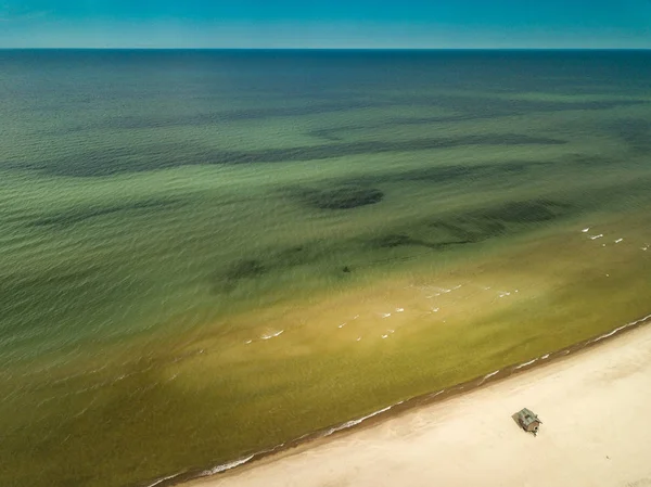 Small sauna house on the seashore. Bathhouse. Sandy beach.