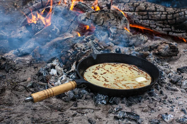 Cooking pancakes on the fire in the forest.