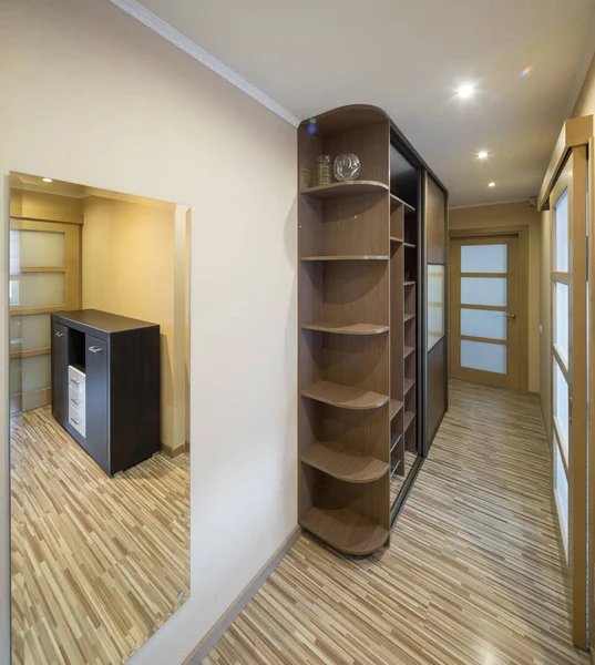 Interior of the flat. Warm tones, wooden floor. Built-in wardrobe