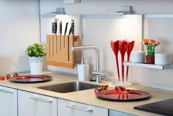 SInk in the modern kitchen. Knives, plates and flowers.