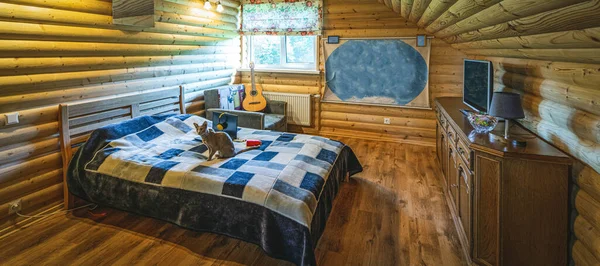 Wooden interior of attic bedroom with furniture. Private country house. Teenager room.