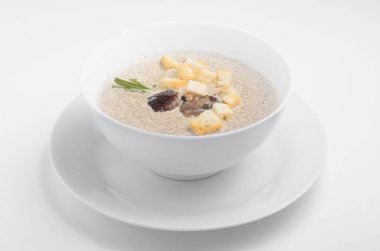 Mantarlı krema çorbası ve sarımsaklı ekmek. Beyaz arka planda beyaz bir tabakta servis edilmiş. Çevrimiçi gıda sipariş katalogları ve menülerinde veya mutfak yayınlarında kullanmak için