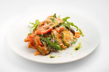 Izgara sebzeli ve soslu Tagliatelle. Beyaz arka planda, beyaz bir tabakta güzel servis. Menü tasarımı ve yemek dağıtım servisinde kullanım için.