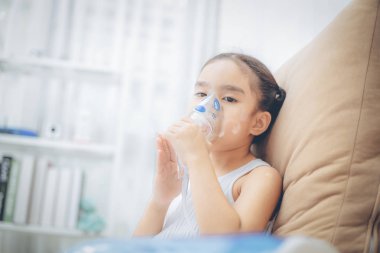Şirin Asyalı çocuk hasta enhalasyon tedavisi inhaler yumuşak akışı bronchodilator duman maskesi tarafından.