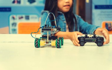 Robot ve uzaktan kumanda bakarak çocuk. Asyalı çocuk programlama robot, sınıf, eğitim kavramı