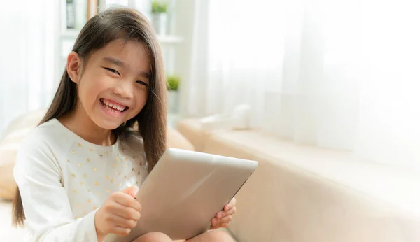 Ásia Bonito Criança Jogar Jogos Com Tablet Sorrindo Enquanto Sentado — Fotografia de Stock