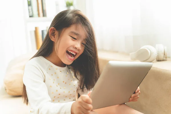 Asian Cute Dziecko Grając Gry Tablecie Uśmiechając Się Siedząc Kanapie — Zdjęcie stockowe