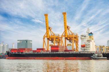 Tersane arka planında çalışan vinç köprüsüne sahip Uluslararası Konteyner Kargo gemisi, lojistik ithalat arka planı ve taşımacılık endüstrisi.