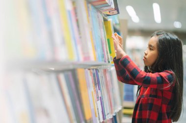 Küçük Asyalı çocuk kitapları bookshelf toplama