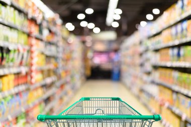 Boş yeşil alışveriş arabasıyla süpermarket koridoru