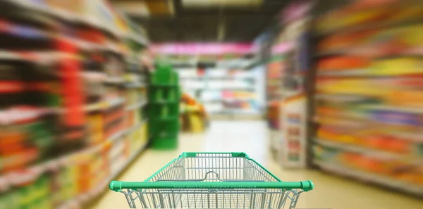 Supermarkt-Gang mit leerem grünen Einkaufswagen — Stockfoto