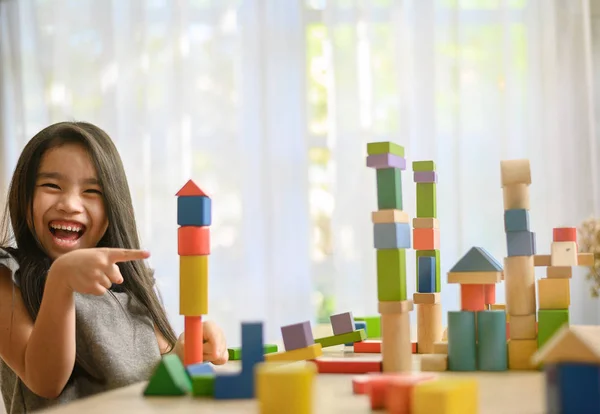 Маленька дівчинка грає з будівельними іграшковими блоками, будуючи буксир — стокове фото
