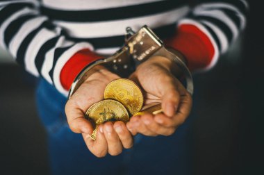 Altın Bitcoin tutan el. Sonra kelepçe ile suç adam 