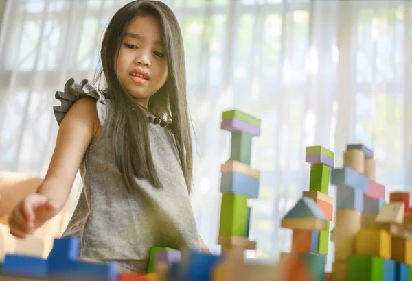 Niña jugando con bloques de juguete de construcción construyendo un remolque — Foto de Stock