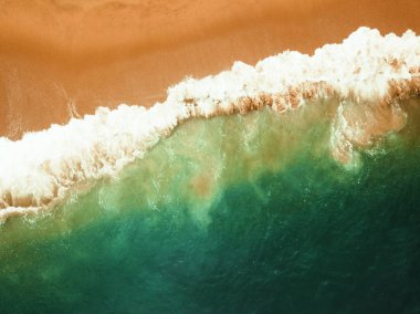 Kıyıya ulaşan okyanus dalgaları ile havadan drone üst görünümünde Plaj.