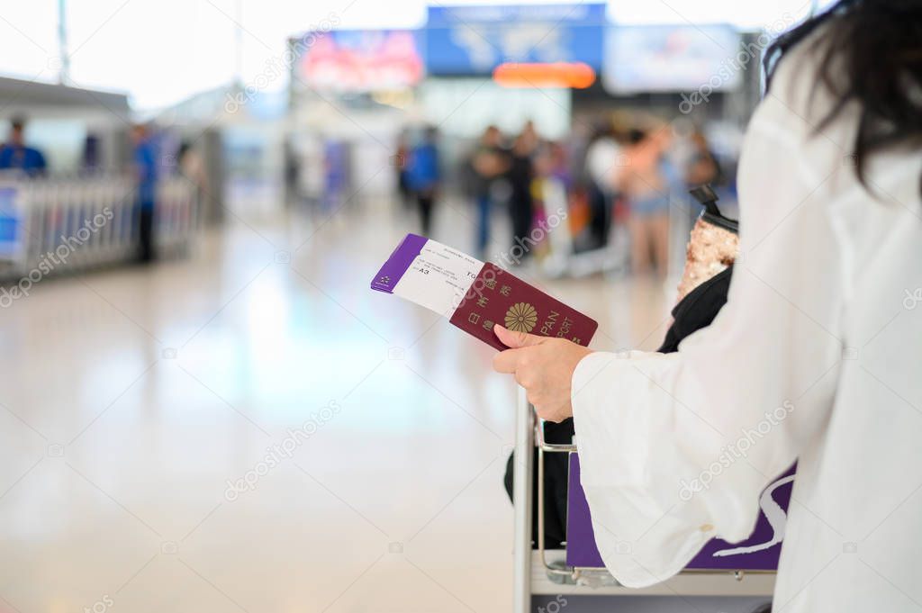 Closeup of girl holding passports and boarding pass at airport 