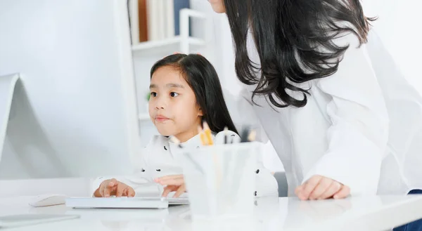 Happy Little girl looking at computer with her mother — Stock Photo, Image