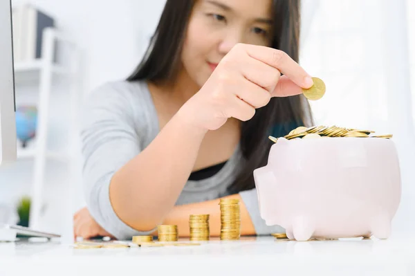 Woman putting golden coin in pink piggy bank. saving money, budg — Stock Photo, Image