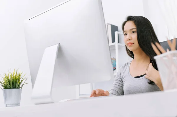 Азіатська домогосподарка працює на комп'ютері в її домашньому офісі працює d — стокове фото
