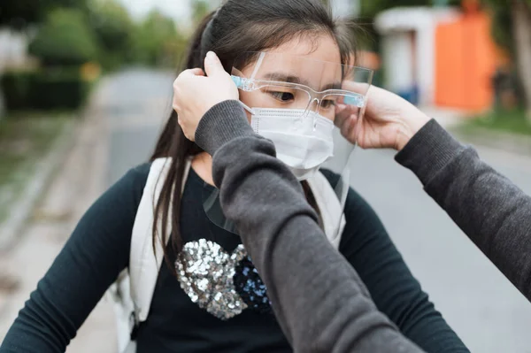 어머니는 학교에 준비를 공원에서 보호하기 얼굴에 마스크를 씌운다 학교의 개념으로 — 스톡 사진