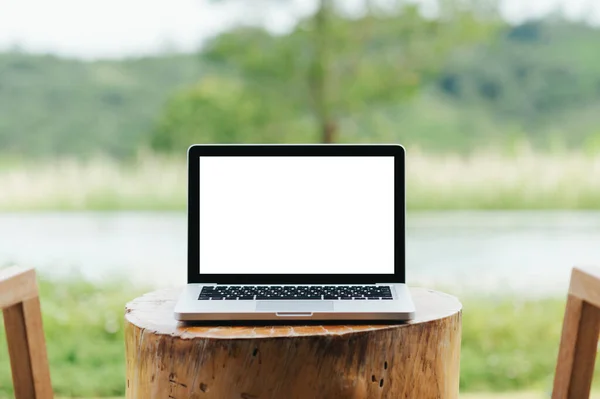 Laptop Prázdnou Obrazovkou Prázdné Místo Stole Zeleným Přírodním Pozadím — Stock fotografie