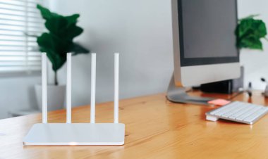 Modern Wi-Fi yönlendirici ofisteki ışıklı masada.
