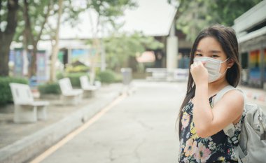 Okula dönelim. Sırt çantalı Asyalı kız çocuğu okula gidiyor. Covid-19 Coronavirus pandemiği. Yeni normal yaşam tarzı. Eğitim konsepti..