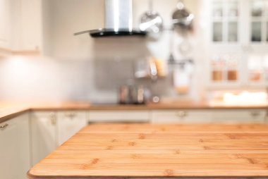 Boş ahşap masa yüzeyi, bulanık mutfak arka planı, yemek sunumu, yemek pişirme konsepti ve ürün ekran şablonu için mükemmel..