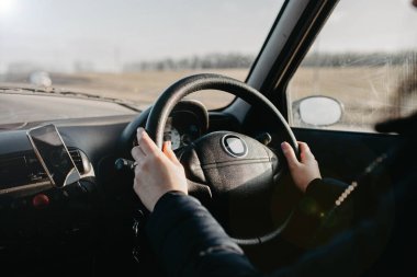 Sürücünün direksiyondaki kadın elleri.