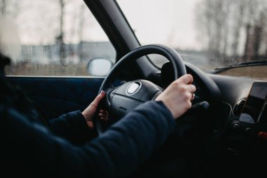 Sürücünün direksiyondaki kadın elleri.