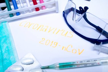 Coronavirus tanı ve tedavi analiz konsepti. Solunum maskeli bir laboratuar masası, steteskop, kan tüpleri, tabletler. Covid 2019