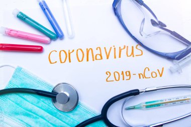 Coronavirus tanı ve tedavi analiz konsepti. Solunum maskeli bir laboratuar masası, steteskop, kan tüpleri, tabletler. Covid 2019
