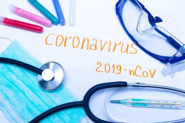 Coronavirus tanı ve tedavi analiz konsepti. Solunum maskeli bir laboratuar masası, steteskop, kan tüpleri, tabletler. Covid 2019
