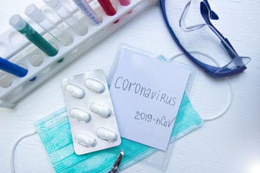 Maskeli ve haplı 2019 ncov yazılı gözlük ve test tüpleri, bulaşıcı koronavirüsü önleme salgını konsepti 