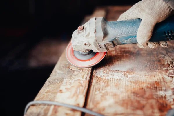woodwork, a grinder cuts old paint and varnish from a solid wood board. furniture restoration.