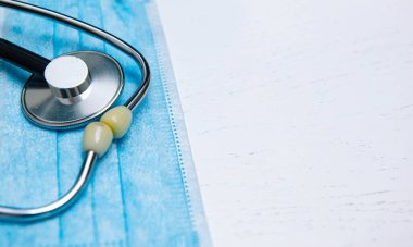 Steteskop ve koronavirüs konsepti olan doktor için tıbbi koruyucu maske  