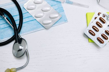 Steteskoplu doktor için tıbbi koruyucu maske ve haplı şırınga, tıbbi teşhis ve terapi kavramı