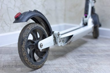 Yeni modern elektrikli scooter duvarın yanında şarj oluyor, yakın görüş 