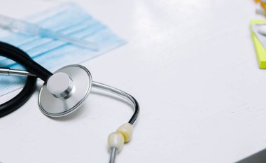 Steteskop ve şırıngalı doktor için tıbbi koruyucu maske, koronavirüs konsepti.  