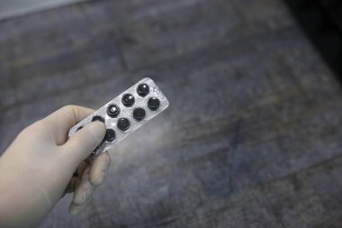 Doktor eldiveni elinde ilaç hapları, tıbbi teşhis ve terapi konsepti tutuyor.