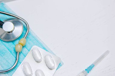 Steteskop haplarla, tıbbi maske şırıngayla, tıbbi tanı konseptiyle ve terapiyle