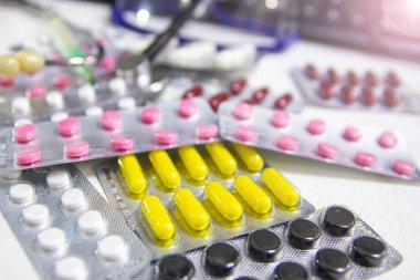 Renkli eczacılık hapları ve termometresi olan steteskop güvenlik gözlüklü klavye, tıbbi tanı ve terapi konsepti.