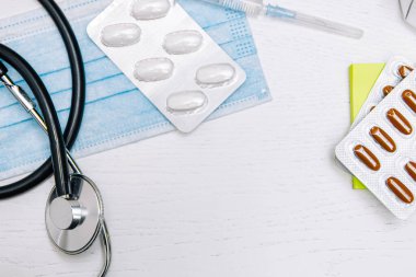 Steteskoplu doktor için tıbbi koruyucu maske ve haplı şırınga, tıbbi teşhis ve terapi kavramı