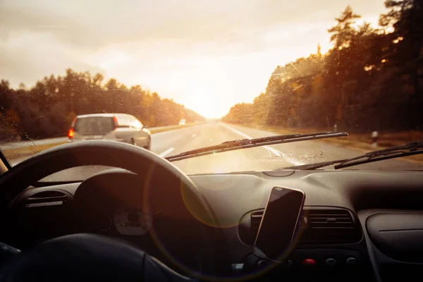 interior view of  car driving on road at sunset