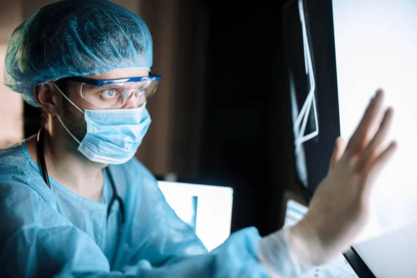 Arzt Schutzuniform Und Brille Blickt Krankenhaus Auf Röntgenbild — Stockfoto